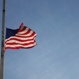 American flag flying at half-staff against a clear blue sky on Memorial Day in Colorado