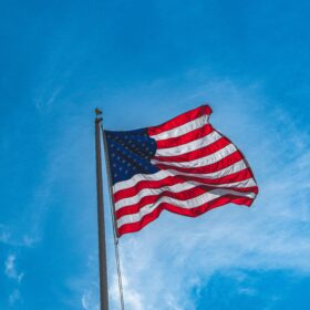 American flag flying from a full flagpole with eagle topper and halyard rope — flag display accessories at Flag World Company Aurora Colorado